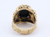 a close up of a gold ring with a black stone in it