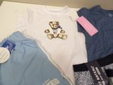 a lot of baby clothes that are laying on a table