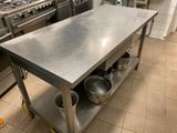 a stainless steel kitchen island with pots and pans on it