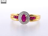 a close up of a gold ring with a ruby and diamond