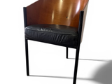a wooden chair with a black leather seat on a white background