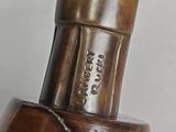 a close up of a vase with a wooden handle