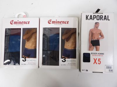 trois boîtes de sous-vêtements pour hommes posées les unes à côté des autres sur une table