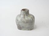 a small vase that is sitting on a white surface