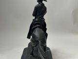 statue of a man riding a horse with a hat on his head
