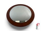 a round mirror with a wooden frame on the wall