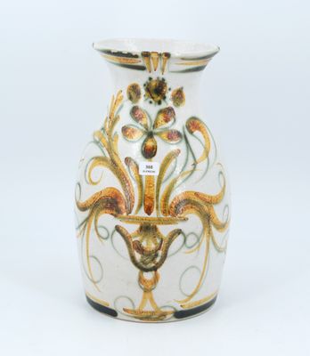 un vase blanc orné d'un motif doré et vert