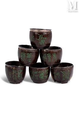 six brown bowls with green writing on them sitting on a white surface