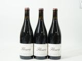 trois bouteilles de vin posées sur une table blanche