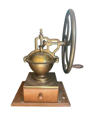 an old fashioned coffee grinder on a wooden stand