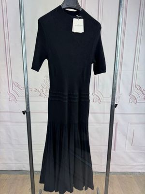 a black dress on a hanger in a room