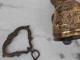 a brass bell with a chain around it on a table