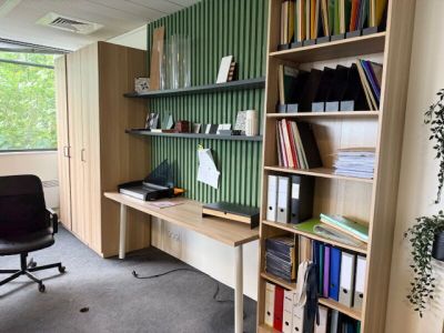 un bureau avec une chaise et une étagère dans le coin