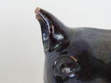 a black cat figurine sitting on top of a table