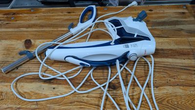 a white and blue steam iron on a wooden table