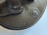 a bronze statue of a man standing on top of a coin
