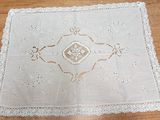 a white table cloth with a design on it on a wooden table