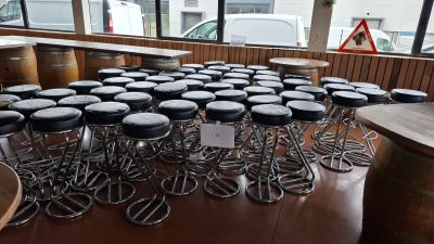 many stools and tables in a room with a lot of windows