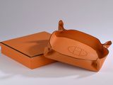 an orange box with a brown handle and a brown lid