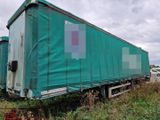 un camion recouvert d'une bâche, garé dans l'herbe