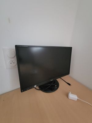 a computer monitor sitting on top of a wooden desk