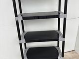 a close up of a black and silver shelf with four shelves