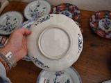 a person that is holding a plate in front of some plates