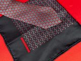the black and red tie is laying on top of a red cloth