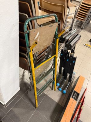 a stack of chairs and a ladder in a room