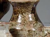 trois vases posés l'un à côté de l'autre sur une table