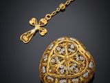 a gold locke with a chain and a cross on a black background
