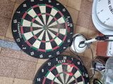 two darts and a toilet on the floor next to each other