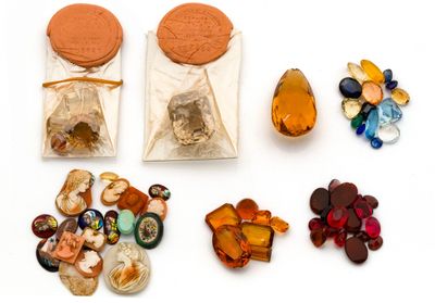 un sac de cailloux et un sac de perles posés sur une surface blanche