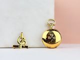 a gold pocket watch and a gold key on a marble surface