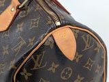 a brown and tan louis vuitton bag on a white surface