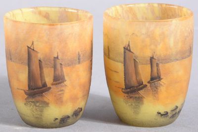 une paire de vases décorés de bateaux, posés sur une table