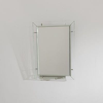 un miroir sur le mur au-dessus d'un lavabo dans une salle de bains