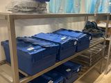 a metal shelf with blue boxes on it in a room