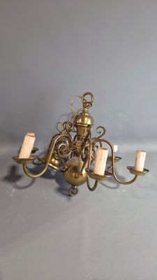 a gold chandelier with five candles on it