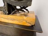 a bronze statue of a woman sitting on a bench