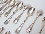 a lot of silver spoons and forks on a table