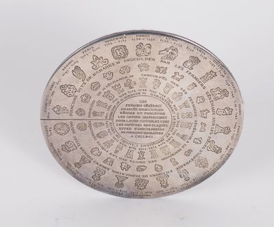 an old silver plate with writing on it on a white surface