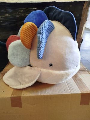 a stuffed whale sitting on top of a cardboard box