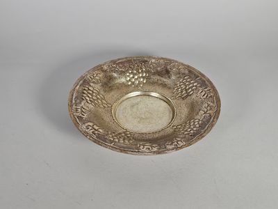 un plat ancien en argent, orné d'un motif sur le bord