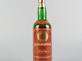 gros plan d'une bouteille de whisky sur une surface blanche