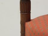 an old wooden chair with a red and green upholstered seat