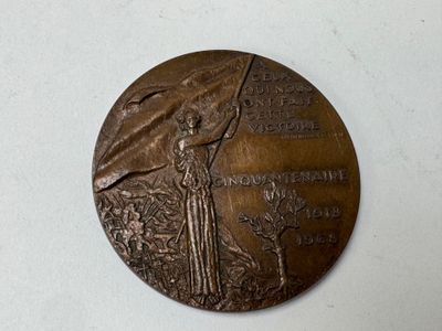 a bronze medal with a woman holding a flag on it