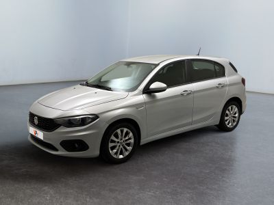 La petite voiture argentée est garée dans une pièce au sol gris.