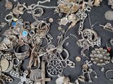 a large collection of silver jewelry on a table