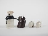 three figurines of a dog, a cat, and a dog